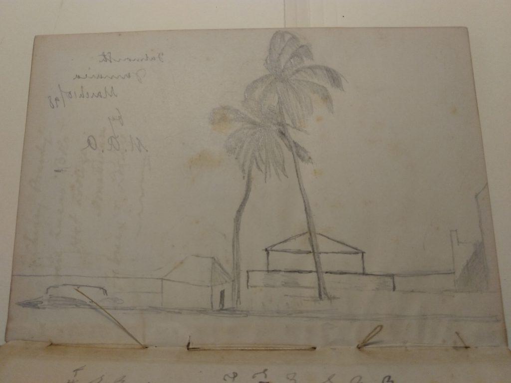 Color photograph of a pencil sketch drawn horizontally across one page of the volume. The sketch depicts two palm trees and a few unidentified buildings. At the top right of the page is handwritten text that reads “Falmouth Jamaica March 10 /98 by M.A.A.” Along the bottom, pieces of string are coming loose from the binding.